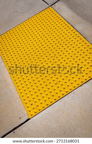 Yellow bumpy tiles, detectable warning surfaces or truncated domes, a tactile paving designed to assist blind or visually impaired people, required by Americans with Disabilities Act (ADA) in USA 