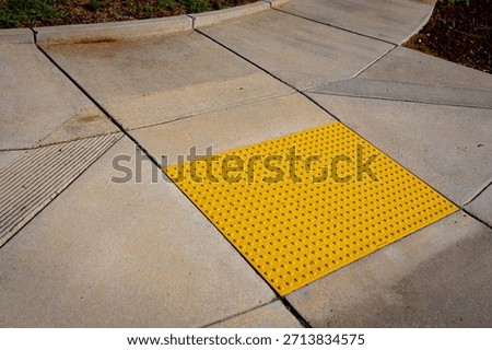 Yellow bumpy tiles, detectable warning surfaces or truncated domes, a tactile paving designed to assist blind or visually impaired people, required by Americans with Disabilities Act (ADA) in USA 