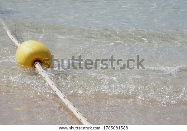 Yellow buoy\
or Tiny Boundary Buoy In Thailand, it is called fish eggs buoy.\
Which is a buoy floating in the sea with rope borders To divide\
into the swimming area for\
tourists.