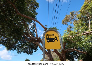 Yellow Bus Stop Sign In Sydney Suburb With Blue Sky