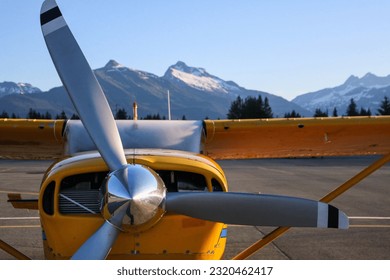 Yellow bush plane, workhorse of the great northern wilderness.  Three bladed propeller powers the stout and reliable high wing aircraft. Remote and isolated communities rely on air travel