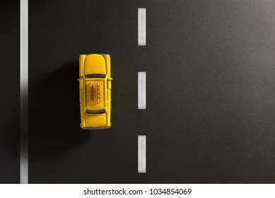 Yellow Cab Toy Car On A Black Background Like Asphalt.