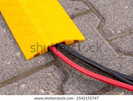 Yellow Cable Protector on Paved Surface