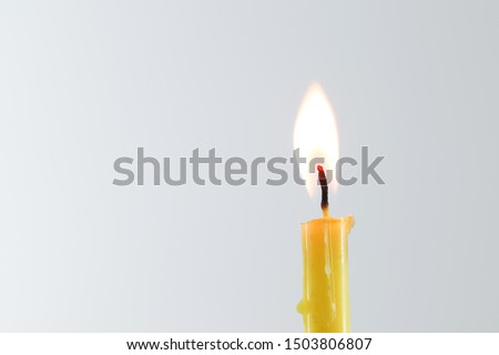 yellow candle flame straight on white background