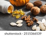 Yellow capsules of omega 3, fatty acid supplement pills with pumpkin seeds and walnuts.