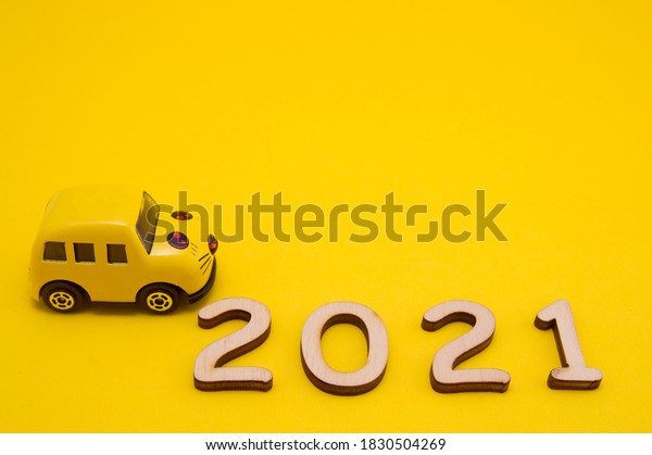 yellow car on yellow\
background with wooden numbers 2021. new year.christmas.food for\
animals.