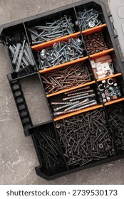 Yellow case with small construction objects on grey background. Vertical photo