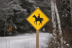 Yellow Caution Horse Riding Sign In A Rural Setting In Winter