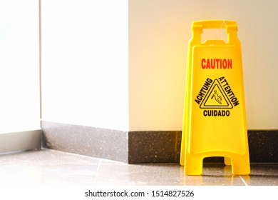 Yellow Caution Wet Floor Sigh Beside Building Wall. Alert For Slippery Tile Floor.