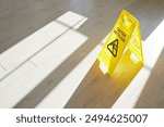 Yellow caution wet floor sign stands on the floor during maintenance, warning of slippery conditions. This safety sign helps prevent slips and falls during cleaning and purification activities.