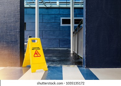 yellow caution wet floor sign with blue building.