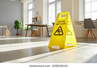 Yellow caution wet floor sign stands on the floor in an office during cleaning. This safety measure warns of slippery conditions, ensuring caution and preventing accidents during cleanup. - Powered by Shutterstock