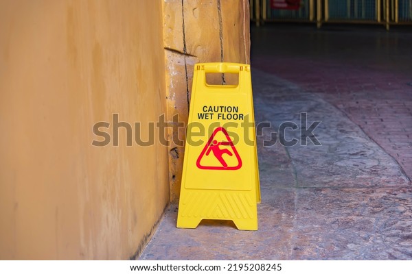 Yellow Caution wet\
floor sign on wet floor