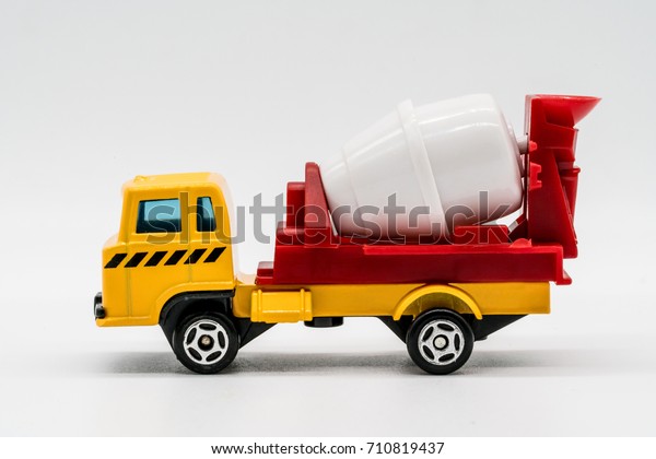 Yellow cement mixer truck toy isolated on white\
background. Building and construction industry, industrial business\
commercial concept.