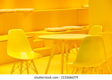 Yellow chairs and table indoor set. Contemporary comfortable plastic furniture   
