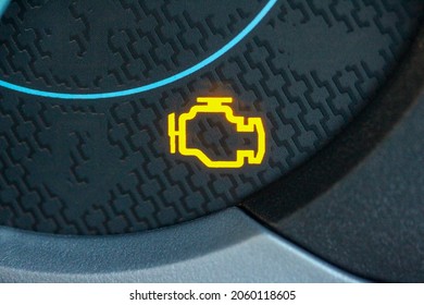 Yellow check engine light glowing in a new car gauge cluster