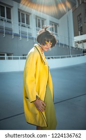 Yellow Chick Outfit. Unusual Sloppy Woman With Wild Hair Wearing Oversized Coat And Giant Silver Earrings