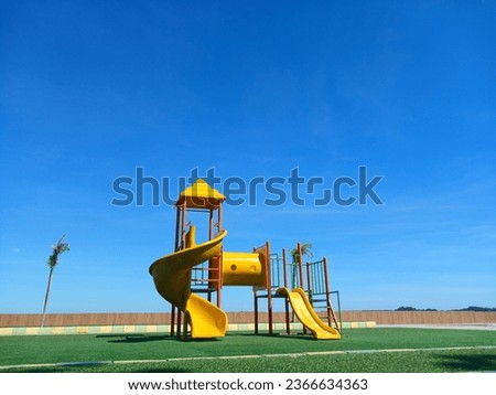 A yellow children's play area on the beach with blue skies
