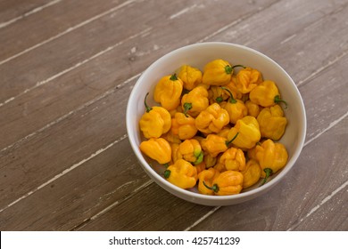 Yellow chilli Naga viper in bowl  On the wooden background