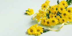 Yellow Chrysanthemums Bouquet With Ribbon On The Turquoise Background. Festive Yellow Chrysanthemums As A Gift For Mother's Day, Women's Day Or Any Holiday. Banner Photo With Space For Greeting.