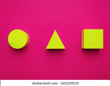 Yellow circle, triangle and square made of paper on a bright purple background. Creative futuristic concept. 3D effect.