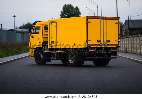 Yellow city sewer cleaning service truck.\
Urban landscape. Rear three quarter\
view.