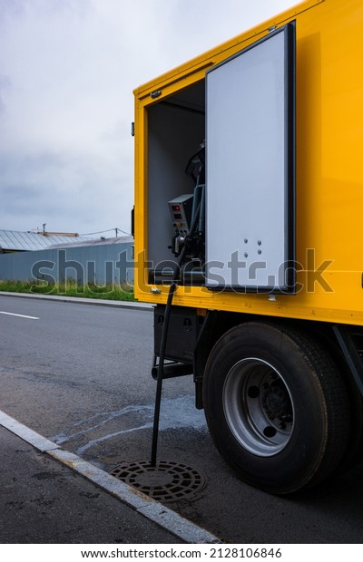 Yellow city\
sewer cleaning service truck. Equipment for hydraulic flushing of\
urban sewerage. Signal flashing\
beacon.