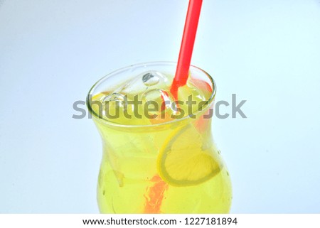 yellow cocktail with ice and lemon closeup on white