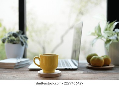 yellow coffee cup and laptop and white flowers on white table indoor work from home - Powered by Shutterstock