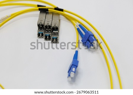 Yellow coiled fiber optic patch cord with blue connectors SFP modules are essential for high-speed data transmission over fiber optic networks.	