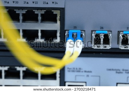 Yellow coiled fiber optic patch cord with blue connectors SFP modules are essential for high-speed data transmission over fiber optic networks.