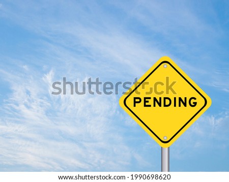 Yellow color transportation sign with word pending on blue sky background