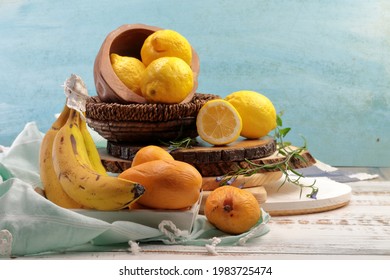 Yellow colored fruits still life which inclused, Banana, Lemons and Mangoes on wooden background.