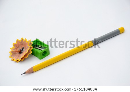 the yellow colour wooden peels pencil with waste flower and green sharpner isolated on white background.