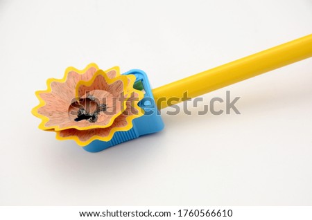 the yellow colour wooden pencil with sky blue sharpner isolated on white background.