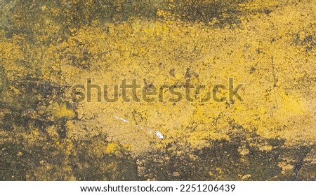 Yellow concrete wall with black mildew stains and cracks