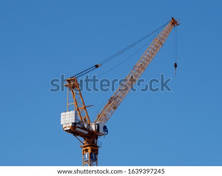 Similar – Image, Stock Photo Yellow construction crane and tree trunks in front of a blue sky