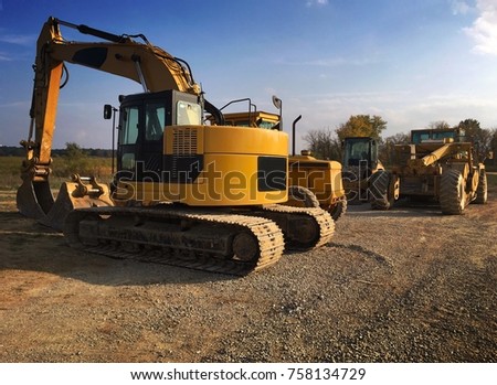 Yellow construction and excavation equipment including backhoe bulldozer and grader