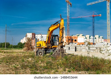 yellow construction excavator stands on the construction site - Shutterstock ID 1488453644