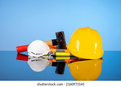 Yellow Construction Helmet, Sledgehammer And Vest As A Renovation Concept.