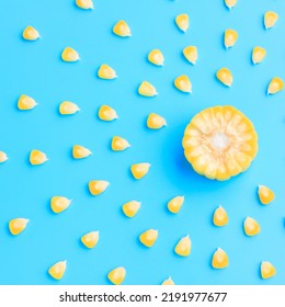 Yellow Corn Cob Slice With Scattered Seeds On Blue Background