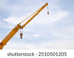 Yellow Crane Boom with Hook Against Clear Sky