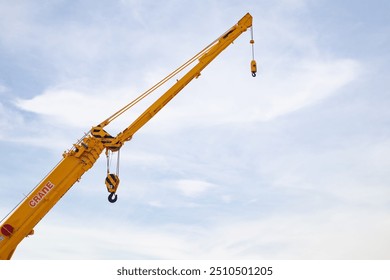 Yellow Crane Boom with Hook Against Clear Sky