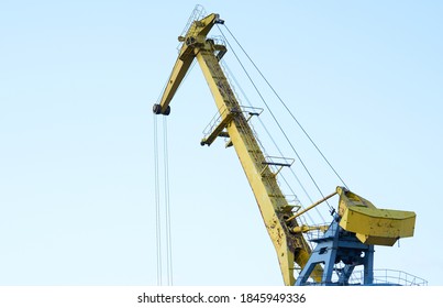 Yellow crane in cargo port translating coal. Industrial scene