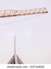 Yellow Crane Towering Over A Sky Scraper