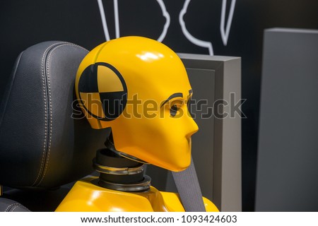 Yellow crash test dummy in a car seat.