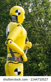 yellow crash test dummy statue on green foliage background - Shutterstock ID 1144710527