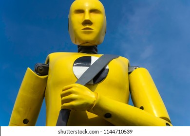 yellow crash test dummy statue on blue sky background