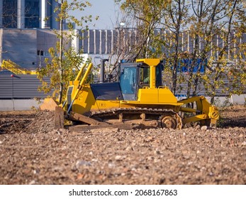 Yellow Crawler Bulldozer With Blade And Plow Working At A Construction Site. Site Preparation For The Construction Of Buildings And Structures. Heavy Construction Equipment