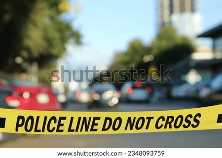Yellow crime scene tape blocking way on street